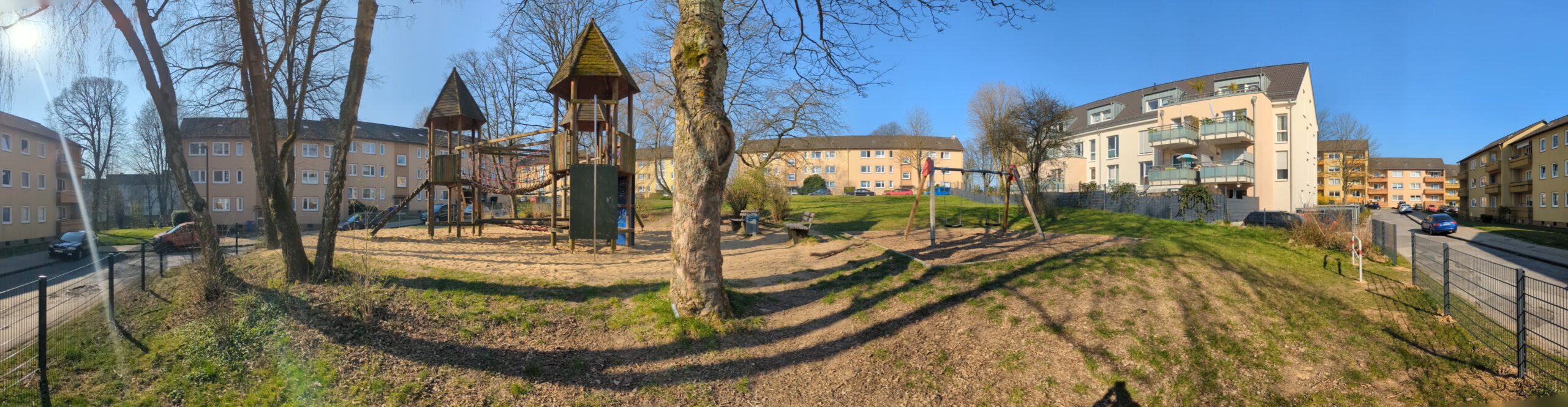 Spielplatz mit Spielgerüst, Schaukel, Rasenfläche und Bänken